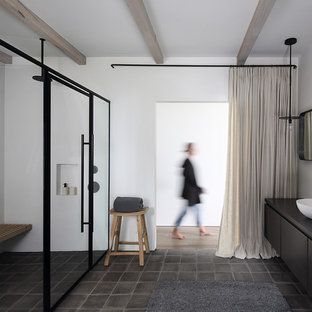 Esempio di una stanza da bagno padronale minimalista con ante lisce, doccia a filo pavimento, pareti bianche, pavimento in terracotta, lavabo a bacinella, porta doccia a battente, ante nere, pavimento grigio e top nero