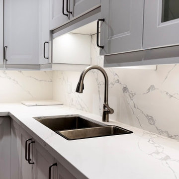 Bright White Transitional Kitchen with Quartz Peninsula and Full Slab Backsplash