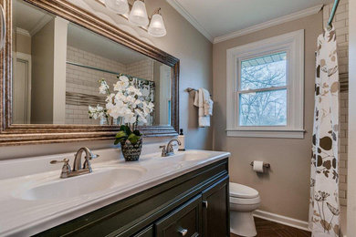 Example of a small classic ceramic tile and brown floor bathroom design in Nashville with black cabinets, beige walls and beige countertops