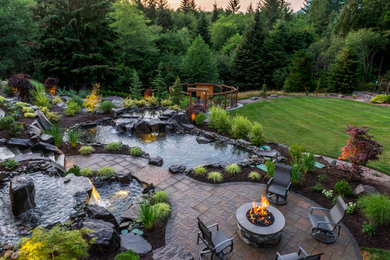 Foto de jardín de estilo americano extra grande en patio trasero con cascada y adoquines de piedra natural