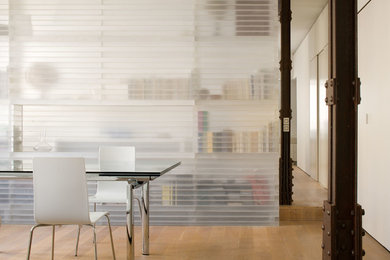 Diseño de comedor de cocina industrial de tamaño medio con paredes blancas, suelo de madera en tonos medios y suelo marrón