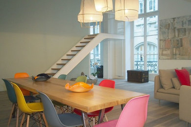 This is an example of a large contemporary open plan dining in Paris with grey walls and grey floor.