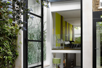 Contemporary dining room in London with feature lighting.
