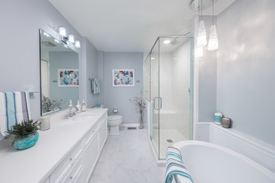 Photo of a mid-sized contemporary master wet room bathroom in Chicago with flat-panel cabinets, white cabinets, a drop-in tub, a one-piece toilet, beige walls, marble floors, an undermount sink, engineered quartz benchtops, white floor and a sliding shower screen.