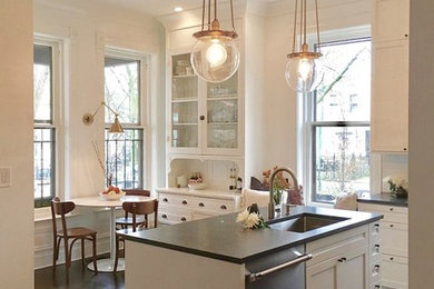 Example of a mid-sized transitional l-shaped dark wood floor and brown floor eat-in kitchen design in Chicago with an undermount sink, shaker cabinets, white cabinets, white backsplash, subway tile backsplash, stainless steel appliances and an island