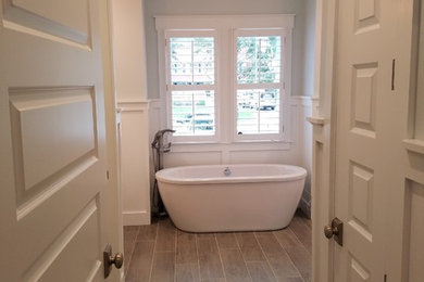 Inspiration for a mid-sized timeless porcelain tile and brown floor freestanding bathtub remodel in Other