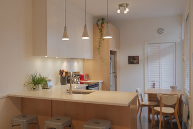 Small trendy l-shaped eat-in kitchen photo in Montreal with an undermount sink, light wood cabinets, quartz countertops and stainless steel appliances
