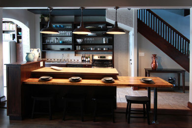 Open concept kitchen - mid-sized industrial galley ceramic tile open concept kitchen idea in DC Metro with a drop-in sink, flat-panel cabinets, dark wood cabinets, concrete countertops, white backsplash, ceramic backsplash, stainless steel appliances and an island