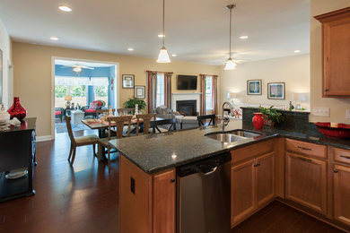 Example of a small country medium tone wood floor great room design in Other with yellow walls, a standard fireplace and a wood fireplace surround