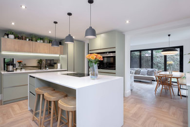 Design ideas for a medium sized contemporary l-shaped open plan kitchen in Other with a built-in sink, flat-panel cabinets, grey cabinets, quartz worktops, mirror splashback, black appliances, an island and white worktops.