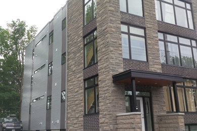 This is an example of a contemporary three-storey grey exterior in Ottawa with metal siding.