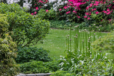 Großer, Halbschattiger Klassischer Gartenweg im Frühling mit Natursteinplatten in Hamburg