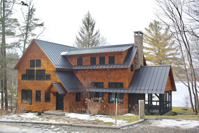 Example of a large mountain style brown two-story wood exterior home design in New York with a metal roof
