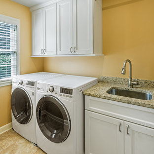 ミルウォーキーの小さいトラディショナルスタイルのおしゃれな洗濯室 (アンダーカウンターシンク、落し込みパネル扉のキャビネット、白いキャビネット、クオーツストーンカウンター、磁器タイルの床、左右配置の洗濯機・乾燥機、オレンジの壁) の写真
