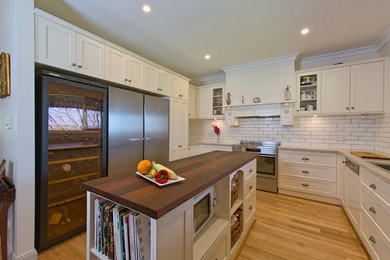 This is an example of a large traditional u-shaped separate kitchen in Adelaide with a double-bowl sink, shaker cabinets, white cabinets, quartz benchtops, white splashback, subway tile splashback, stainless steel appliances, medium hardwood floors and with island.