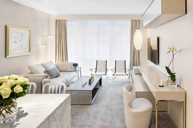 Example of a small trendy open concept medium tone wood floor living room design in New York with gray walls and a wall-mounted tv