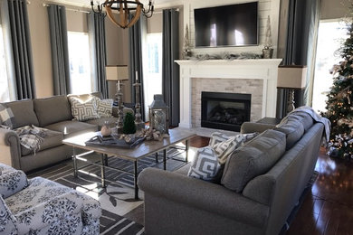 Design ideas for a mid-sized country enclosed family room in Other with grey walls, dark hardwood floors, a standard fireplace, a brick fireplace surround and a wall-mounted tv.