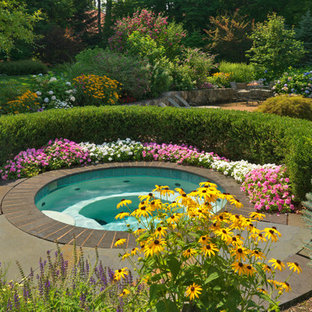 Klassisk inredning av en stor njurformad pool på baksidan av huset, med spabad