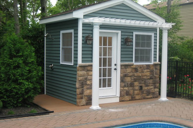 This is an example of a small traditional backyard rectangular pool in New York with a pool house and concrete pavers.