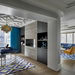 Inspiration för klassiska arbetsrum, med grå väggar, mellanmörkt trägolv, en dubbelsidig öppen spis, ett fristående skrivbord och brunt golv