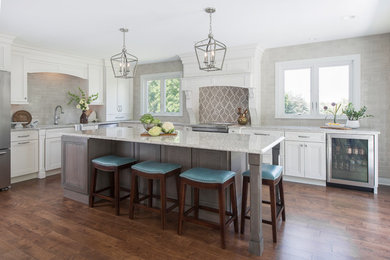 Mid-sized transitional u-shaped medium tone wood floor and brown floor eat-in kitchen photo in St Louis with an undermount sink, recessed-panel cabinets, white cabinets, beige backsplash, ceramic backsplash, stainless steel appliances and an island