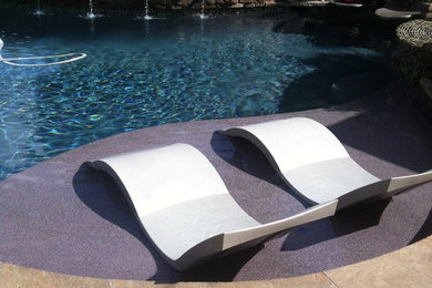 This is an example of a contemporary backyard custom-shaped lap pool in Houston with natural stone pavers.