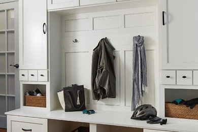 Example of a mid-sized classic medium tone wood floor and brown floor mudroom design in Orange County with beige walls