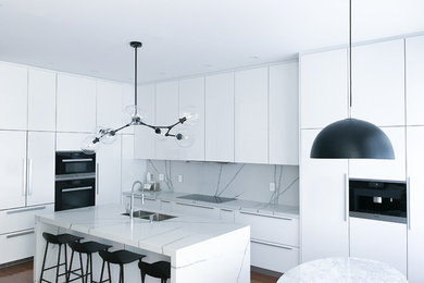 Modern kitchen in Toronto with white cabinets and with island.