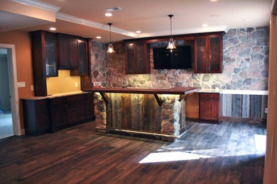 Basement - large rustic walk-out dark wood floor, brown floor and vaulted ceiling basement idea in Philadelphia with a bar