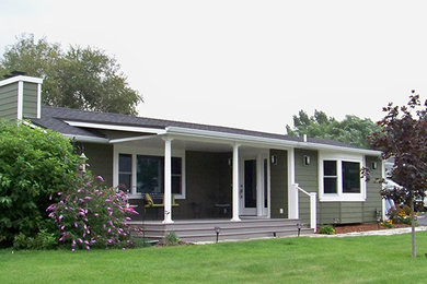 Example of a mid-sized classic green one-story wood exterior home design in Other with a shingle roof
