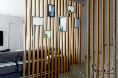 Imagen de escalera en L contemporánea con barandilla de madera