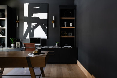 Exempel på ett mellanstort modernt arbetsrum, med svarta väggar, ljust trägolv, ett inbyggt skrivbord och brunt golv