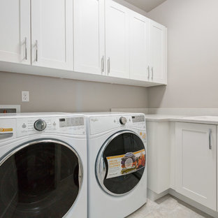 Small classic l-shaped separated utility room in Seattle with a built-in sink, shaker cabinets, white cabinets, limestone worktops, travertine flooring, a side by side washer and dryer, beige floors and grey walls.