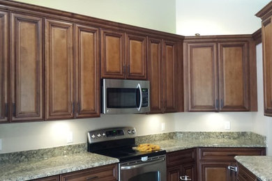 Photo of a traditional kitchen in Orlando with raised-panel cabinets and medium wood cabinets.