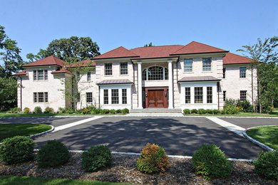 Large elegant white two-story brick house exterior photo in New York with a hip roof and a shingle roof