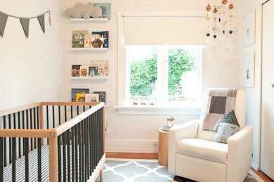 This is an example of a small transitional gender-neutral nursery in Vancouver with white walls.