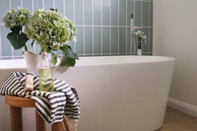 Photo of a medium sized modern family bathroom in West Midlands with medium wood cabinets, a freestanding bath, a walk-in shower, green tiles, white walls, a single sink and a floating vanity unit.