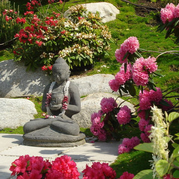 Detail eines asiatischen Gartens mit Buddha, Rhododendron und Granitfindlingen