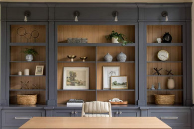 Ejemplo de despacho clásico renovado de tamaño medio con paredes beige, suelo de madera clara, escritorio independiente y vigas vistas