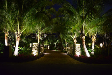 Design ideas for a large mediterranean front yard driveway in Tampa with natural stone pavers.