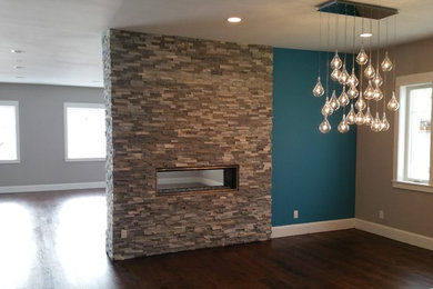 Inspiration for a mid-sized contemporary dark wood floor great room remodel in Denver with blue walls, a two-sided fireplace and a stone fireplace