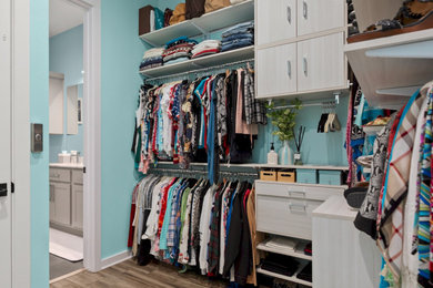 Walk-in closet - mid-sized modern women's brown floor and laminate floor walk-in closet idea in Austin with flat-panel cabinets and light wood cabinets