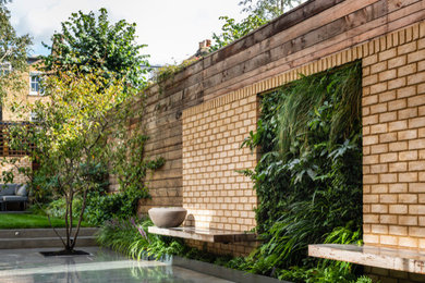 Inspiration for a medium sized contemporary back formal partial sun garden for summer with a living wall and concrete paving.