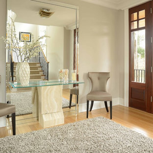 Foto di un grande ingresso minimalista con pareti grigie, pavimento in bambù, una porta in legno bruno e una porta singola