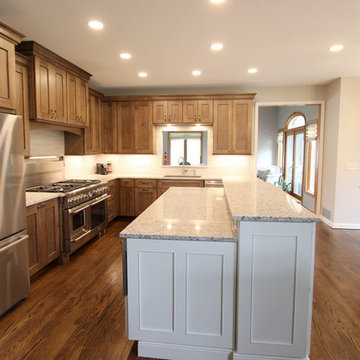 Two Toned Kitchen with White Island and Great Room Stacked Stone Fireplace