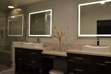 Large minimalist master white tile and pebble tile vinyl floor and brown floor bathroom photo in Los Angeles with shaker cabinets, dark wood cabinets, beige walls, a vessel sink, quartzite countertops, a hinged shower door and white countertops