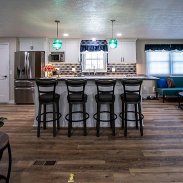 White Kitchen with Blue Tiled Backsplash and Two Tier Island