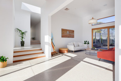На фото: гостиная комната в современном стиле с бетонным полом, стандартным камином и фасадом камина из камня с