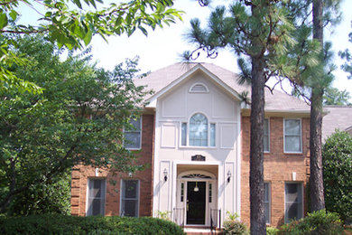 Inspiration for a red two-story brick exterior home remodel in Other