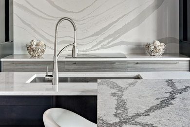 Kitchen photo in Minneapolis with an undermount sink, quartz countertops, white backsplash, stone slab backsplash, an island and white countertops